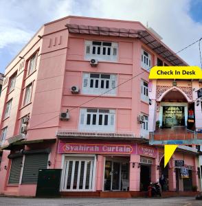 瓜拉丁加奴上城生态酒店 的粉红色的建筑,上面有读取登机牌的标志