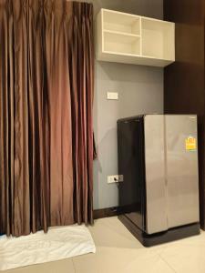 武里南Jt Place Buriram的不锈钢冰箱,带窗帘的房间