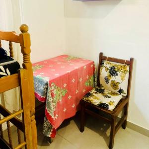 大普拉亚Xixova Hostel Japui são Vicente的一间设有一张桌子和一把椅子的房间,配有红色的桌布