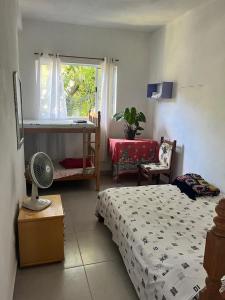 大普拉亚Xixova Hostel Japui são Vicente的一间卧室配有一张床、一张书桌和一个窗户。