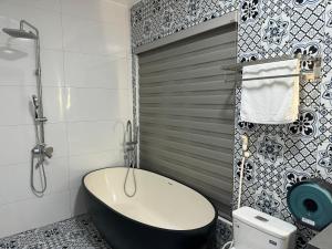 宁平Azalea Tam Coc Ninh Bình的一间带黑色浴缸和卫生间的浴室