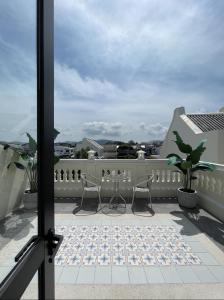 普吉镇Hawa House Phuket的阳台配有两把椅子和一张桌子
