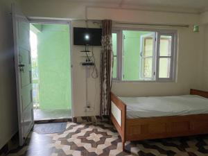 BhurtukMountaintop Guest House的一间小卧室,配有床和窗户