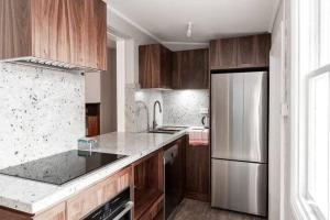 悉尼Modern Heritage Home - Stunning Bridge Views的厨房配有木制橱柜和不锈钢冰箱。