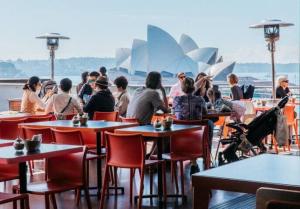 悉尼Modern Heritage Home - Stunning Bridge Views的一群坐在歌剧院前桌旁的人