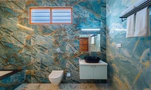 蓬蒂切里FabHotel Prime AR Phalazzo Resort的一间带卫生间和石墙的浴室