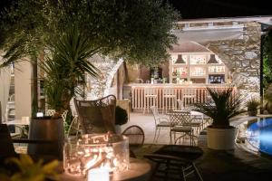 萨索斯尼科拉塔豪华别墅酒店的一个带桌椅的庭院和一间酒吧