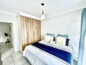 比勒陀利亚TK’s Penthouse - The Blyde的一间卧室配有一张带蓝白色枕头的大床