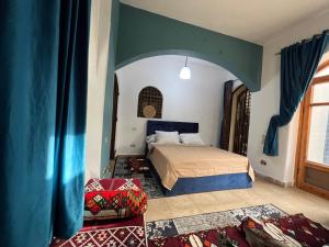 Al Mazghūnahpyramids view Guest villa的一间卧室配有一张蓝色天花板的床