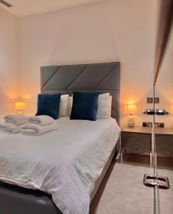 伦敦Luxury 2 Bedroom Apartment in Old Street, London的卧室配有带蓝色枕头的大型白色床