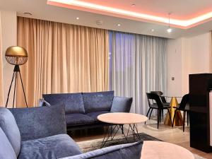 伦敦Luxury 2 Bedroom Apartment in Old Street, London的客厅配有蓝色的沙发和桌子