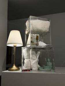 瓦伦西亚Naap的一个带毛巾的玻璃盒子和桌子上的一盏灯