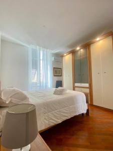 斯培西亚Casa Giulia La Spezia的卧室设有白色的床和大窗户