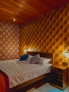 MawatagamaMiracle Sand Country Resort的一间卧室配有一张带大围墙的床