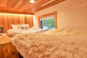 御代田町サウナ・ジャグジー・完全貸し切りという贅沢　大人の秘密基地　Tiny Cabin TATEGU#02的木制客房内的一间卧室,配有一张床
