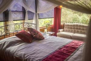 克恩维尔Quiet Mind Lodge, Spa & Retreat Sequoias的一间卧室配有一张床、一张沙发和一个窗口