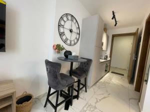 阿克拉Hovah Luxury Suite的一间设有桌子、两把椅子和时钟的房间