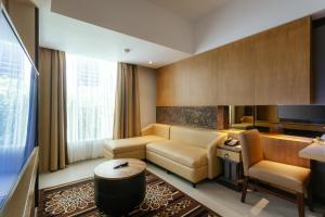 塞米亚克Horison Ultima Seminyak Bali - CHSE Certified的客厅配有沙发和桌子