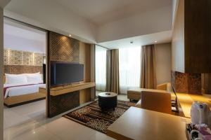 塞米亚克Horison Ultima Seminyak Bali - CHSE Certified的酒店客房,配有床和电视