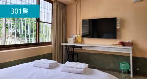 Dalin成都旅社民宿的酒店客房设有一张床铺,墙上配有电视。