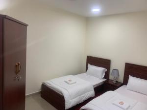 阿吉曼Family rooms with beach view يستضيف مكان الإقامة هذا العائلات فقط的酒店客房,配有两张带白色床单的床