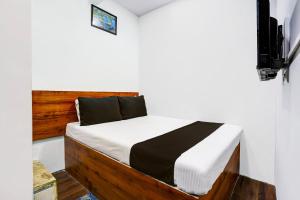 孟买Hotel Metro House的一张带木制床头板的床