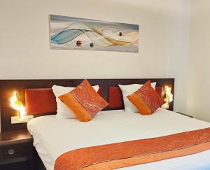 阿纳姆CN-Hotel的一间卧室配有带橙色和白色枕头的床