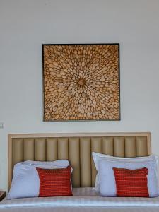 RuaMorika Villa的床上方的图片,有两个红色枕头