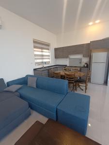 Al QasţalVilla rotana airport road的一间带蓝色沙发的客厅和一间厨房