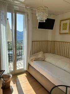 洛迦诺奥兰达膳宿公寓酒店的一间卧室设有一张床和一个大窗户