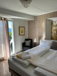洛迦诺奥兰达膳宿公寓酒店的一间卧室配有一张大床、椅子和窗户