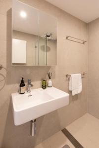 悉尼2BDR Brand New Apt - Moments from RNSH & St Leonards的浴室配有白色水槽和淋浴。