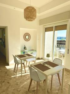 福尔米亚Villa Magnolia的一间带桌椅的用餐室和窗户。