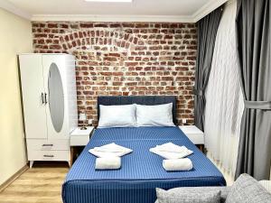 伊斯坦布尔Golden Stay Boutique Hotel Taksim的一间卧室设有蓝色的床和砖墙
