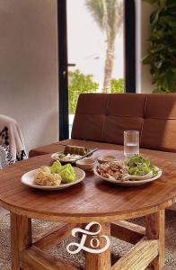 Phu YenLo Villa - Venuestay的一张木桌,上面放着两盘食物