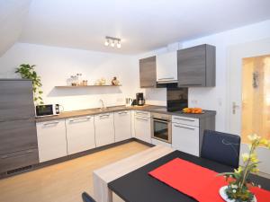 梅舍德Apartment near ski area in Wehrstapel in Sauerland的厨房配有白色橱柜和餐桌