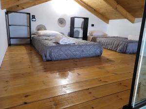 SpílionFontana Leone的铺有木地板的客房内的两张床