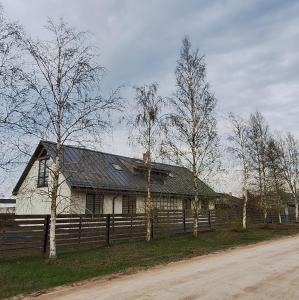 帕维洛斯塔Jūras sāga的白色的房子,有栅栏和树木