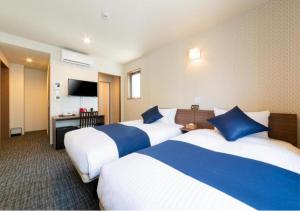 京都HOTEL DORIA的酒店客房设有两张床和电视。