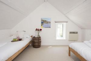 PorthallowRutherglen的白色的阁楼卧室设有两张床和窗户