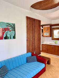 伊里斯斯Seafront Oasis Beach Houses的一间带蓝色沙发的客厅和一间厨房