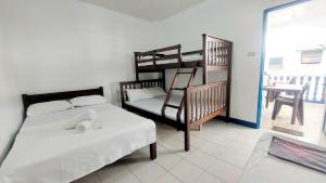 BalateroGalera Pension House的一间带两张床和一张双层床的卧室以及一个阳台