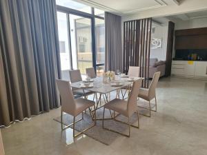 Al Budayyiâ€˜luxurious villa的一间设有玻璃桌和椅子的用餐室