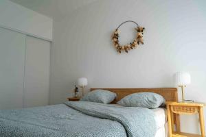 吕埃尔-马尔迈松Ravissant 2 pièces lumineux et moderne的卧室配有一张带花圈的床铺,墙上挂有花圈