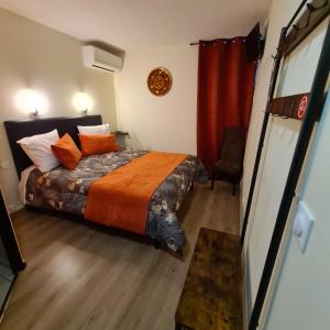 卡尔卡松Hôtel L'Etoile Aéroport - A61的一间卧室配有一张带橙色棉被的床