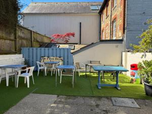 本布里奇The Pilot Boat Inn, Isle of Wight的一组桌子和椅子放在草坪上