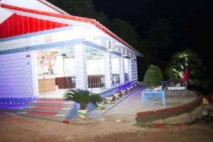TigriShalini Batika & Eco Resort的白色的房子,有红色和蓝色的屋顶