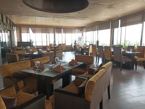 拉合尔Maisonette Hotels & Resorts的用餐室设有桌椅和窗户。