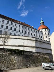 多瑙河畔诺伊堡Zimmer zum vermieten direkt an der Donau und am Schloss的一座白色的大建筑,墙上有塔