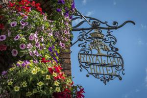 威尔斯浦The Royal Oak Hotel, Welshpool, Mid Wales的花花挂在建筑物边的标志